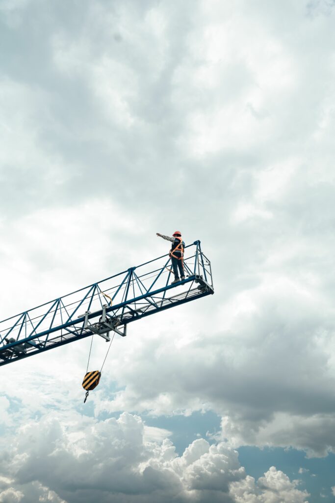 pexels photo 27456517 27456517 A construction worker stands on a crane against a dramatic cloudy sky in Mexico City.